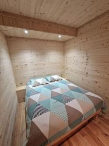 - une chambre avec un lit dans une pièce en bois dans l'établissement Charmant T2 rénové- Praloup 1600-parking privé, proche station, à Uvernet