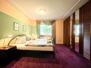 ein Schlafzimmer mit einem großen Bett und einem Fenster in der Unterkunft Villa Ferienhaus EMG für Familien und Gruppen in Celle Hannover in Celle