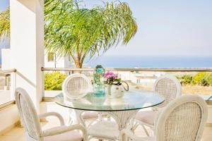 d'une table et de chaises en verre sur un balcon donnant sur l'océan. dans l'établissement Villa Bella Elena, à Káto Váthia