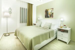 una camera da letto bianca con un letto bianco e una lampada di Rodina Suites Hotel a Kusadası