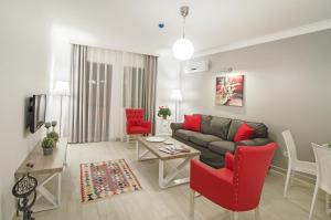 een woonkamer met een bank en rode stoelen bij Rodina Suites Hotel in Kuşadası
