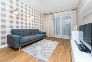 a living room with a couch and a tv at Cztery Oceany 209 in Gdańsk