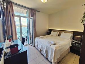 una habitación de hotel con una cama y un balcón en The Manessi City Boutique Hotel, en Poros