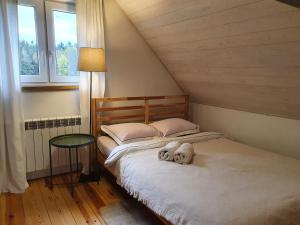 ein Schlafzimmer mit einem Bett mit zwei ausgestopften Tieren darauf in der Unterkunft Kartkówka in Unichowo