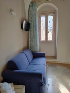 een woonkamer met een blauwe bank en een raam bij Le Stanze di Finya in Gravina in Puglia