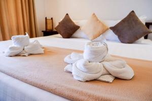 two piles of towels sitting on top of two beds at El Nido Moringa Resort in El Nido