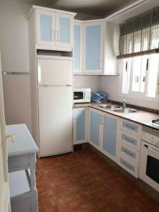 eine Küche mit weißen Schränken und einem weißen Kühlschrank in der Unterkunft El Playaíso de Aguamarga in Agua Amarga