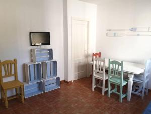 a dining room with a table and chairs and a tv at El Playaíso de Aguamarga in Agua Amarga