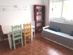 ein Wohnzimmer mit einem Sofa, einem Tisch und Stühlen in der Unterkunft El Playaíso de Aguamarga in Agua Amarga