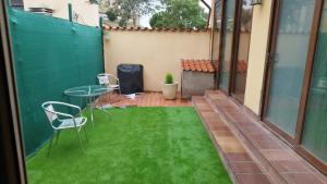 a small patio with a table and chairs on the grass at Esencia Mudayyan in Coca de Alba