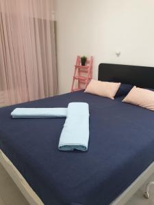 Una cama con sábanas azules y almohadas. en חצבים על הואדי, en Arad
