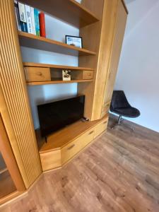 ein Wohnzimmer mit einem TV und einem Bücherregal in der Unterkunft Bezauberndes Stadtidyll in Lichtenstein