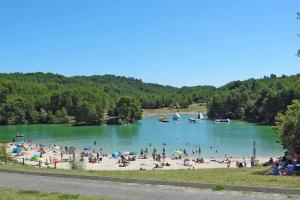 a group of people on a beach in a lake at Bel appartement à Bastide St Louis in Carcassonne