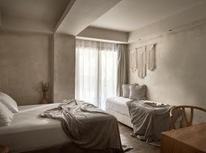 a bedroom with two beds and a window at GARDELLI RESORT in Laganas