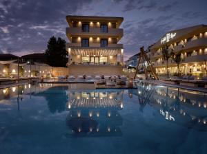 a hotel with a pool in front of a building at GARDELLI RESORT in Laganas