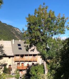 a large house with a balcony and a tree at Maison basse in Vars