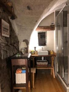 ein Badezimmer mit einem Waschtisch, einem Waschbecken und einem Spiegel in der Unterkunft Maison basse in Vars