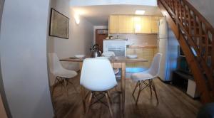 a kitchen with a table and white chairs in a room at Duplex Holidays Andorra in Pas de la Casa