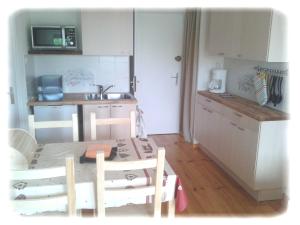 a small kitchen with a table and chairs in a room at Le Cernois -Centrre du village - pistes de luge, ski fond, patinoire, commerces à 100m in Prémanon