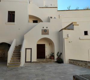 un edificio blanco con escalera y puerta en Le Stanze di Finya, en Gravina in Puglia