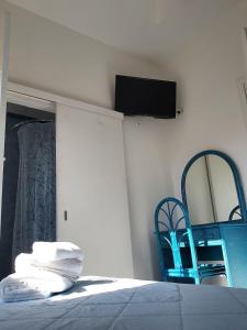 - une chambre avec un lit et une télévision murale dans l'établissement Hotel Sirenetta, à Anzio