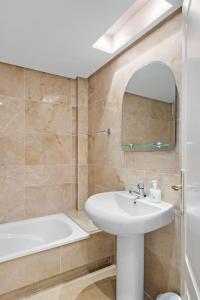 W łazience znajduje się umywalka, wanna i lustro. w obiekcie Costa del Solbeleving pur sang w mieście Castillo de Sabinillas
