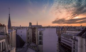 a view of a city skyline at sunset at Hotel Les Bulles De Paris in Paris