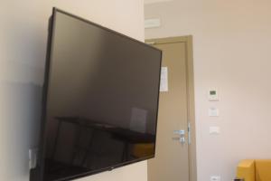 un grand écran de télévision sur un mur à côté d'une porte dans l'établissement Villa cantoni marca superior, à Sabbioneta