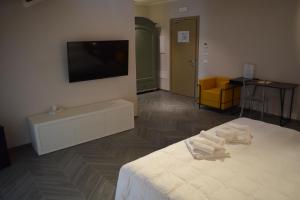 - une chambre avec un lit et une télévision murale dans l'établissement Villa cantoni marca superior, à Sabbioneta