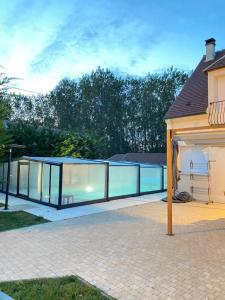 a swimming pool with glass doors on a house at Golden housse in Pont-Sainte-Maxence