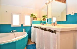 a bathroom with two sinks and a tub and a mirror at Cozy Home In St-Quentin-La-Poterie in Saint-Quentin-la-Poterie