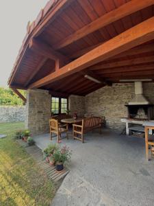 un patio con mesa, sillas y chimenea en Casa Rural Arteondo en Orduña