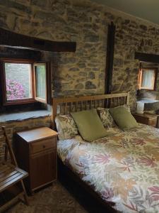 um quarto com uma cama e uma parede de pedra em Casa Rural Arteondo em Orduña