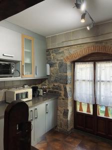 a kitchen with a counter and a brick wall at Casa Rural Arteondo in Orduña