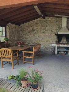 un patio con mesa, sillas y chimenea en Casa Rural Arteondo en Orduña