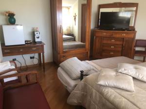 グラヴィーナ・イン・プーリアにあるVilla Radiosaのベッドルーム1室(ベッド2台、テレビ、ドレッサー付)