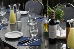 un tavolo con una bottiglia di vino e bicchieri da vino di Eco Nieborów a Nieborów