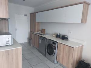 a kitchen with a washer and a washing machine at The Blyde Penthouse in Pretoria