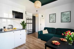 a living room with a green couch and a table at Katedralna Apart's Legnica in Legnica