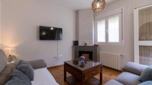 a living room with a couch and a tv on the wall at Camino de la Huerta Montejaque by Ruralidays in Montejaque