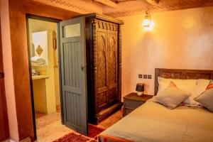 a bedroom with a bed and an open door at Ouednoujoum Ecolodge & Spa in Ouarzazate