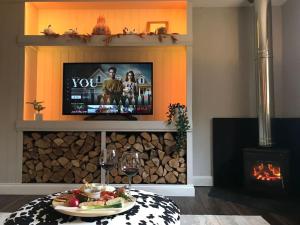 a living room with a tv and a table with food at The Old Dairy - Cosy Country Cottage with Hot Tub & Log Burner in Cupar
