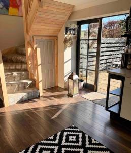 a room with a staircase and a door with a rug at The Old Dairy - Cosy Country Cottage with Hot Tub & Log Burner in Cupar