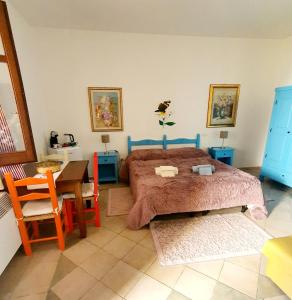 sypialnia z łóżkiem, stołem i krzesłami w obiekcie Camere Sinis Isprocilis w mieście Palmas Arborea
