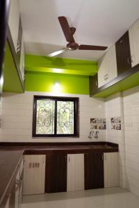 uma cozinha com uma ventoinha de tecto e uma janela em Dhanashree Riverview Hotel em Corgao