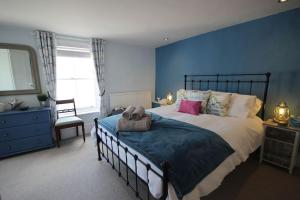 een slaapkamer met een groot bed met een blauwe muur bij Dexter's House in Kent
