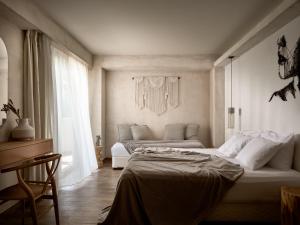 a bedroom with two beds and a couch in it at GARDELLI RESORT in Laganas