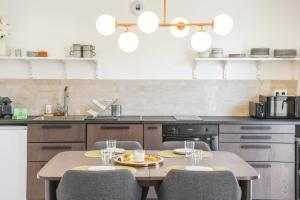 a kitchen with a table with four chairs and a counter at 2 chambre avec balcon et parking in Marseille