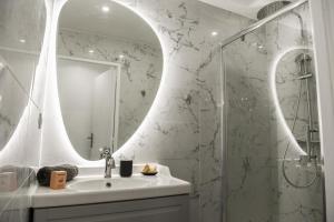 a bathroom with a sink and a shower with a mirror at 2 chambre avec balcon et parking in Marseille
