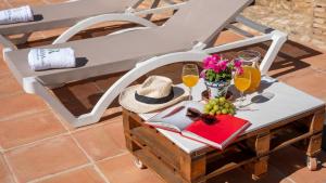 une table avec un chapeau et un livre sur une chaise dans l'établissement El Molar Ronda by Ruralidays, à Ronda
